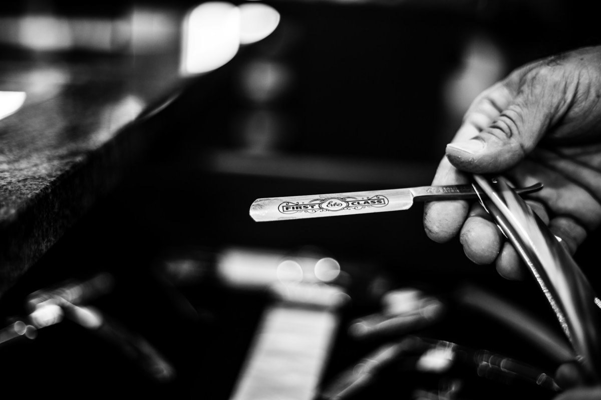 Un gros plan sur un rasoir coupe-chou tenue par un barbier. Photo de Stefan Schauberger sur Unsplash
